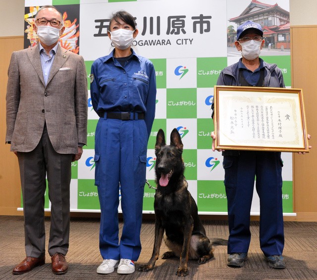 佐々木孝昌市長(左)を訪問した、嘱託警察犬オッシー号と指導手の木村輝子さん(左から2人目)ら=2021年8月26日、青森県五所川原市の五所川原市役所、渡部耕平撮影