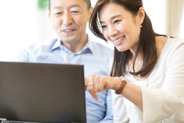 パソコンを見ながら会話をする夫婦