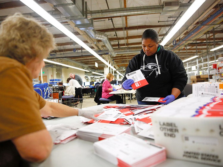 Workers prepare ballots from a drop box for the mail sorting machine during the presidential primary at King County Elections ballot processing center in Renton, Washington, U.S. March 10, 2020. REUTERS/Lindsey Wasson
