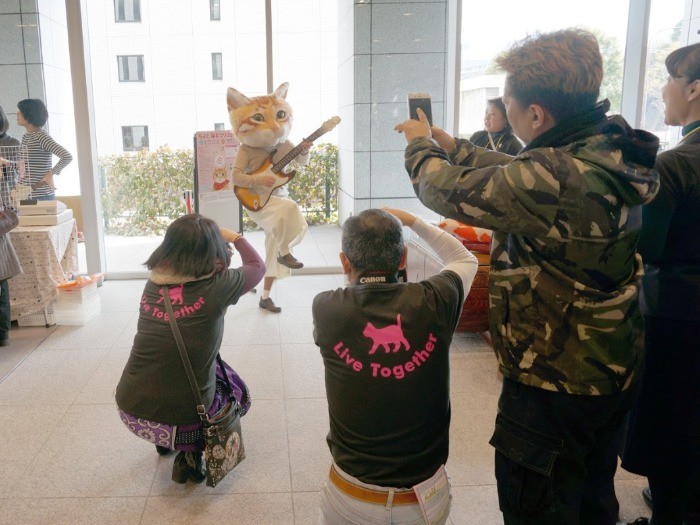 「リアル猫ヘッドアートプロジェクト」。右のジャンパーの男性がアーティストの佐藤法雪さん 撮影:内山美枝子