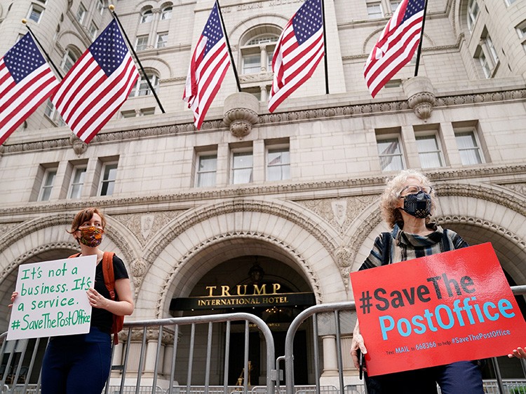 Protestors wearing face masks rally in support of the United States Postal Service (USPS) outside the Trump International Hotel in Washington, U.S. August 22, 2020. REUTERS/Erin Scott