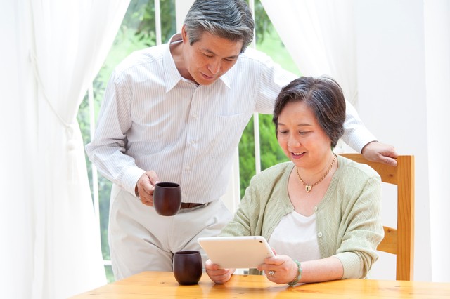 タブレットPCを見るシニア夫婦