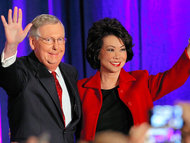 U.S. Senate Minority Leader Mitch McConnell (R-KY) waves to supporters with his wife, former United States Secretary of Labor Elaine Chao, at his midterm election night rally in Louisville, Kentucky, November 4, 2014. Television news networks are projecting that McConnell will win the election. REUTERS/John Sommers II (UNITED STATES - Tags: POLITICS ELECTIONS) - TB3EAB5050RRB