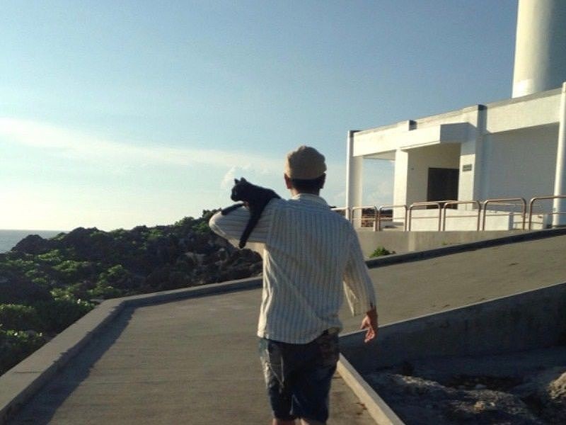 くるを肩に乗せて海を見に行くまさひこさん。なぜか降りようとしなかった (綾子さん提供)