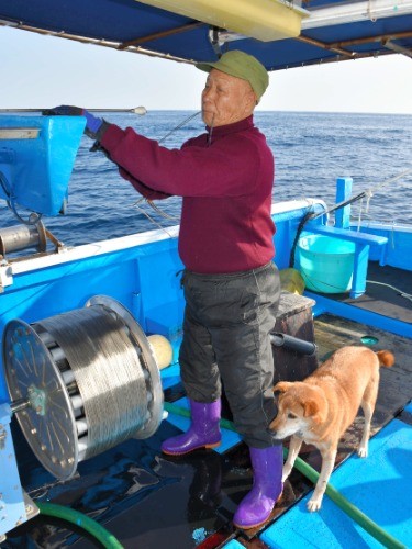 徳永悦男さんと愛犬ジョン=2018年11月30日午前9時36分、高知県室戸市の室戸岬沖、笠原雅俊撮影