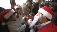 路面電車でサンタクロースが子どもたちにクリスマスプレゼント 岡山市