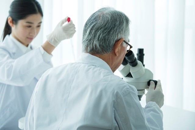 顕微鏡をのぞく男性研究者