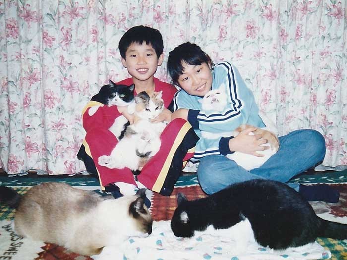たくさんの猫と幼き日の子どもたち。親しかった獣医師は、長男が中2の時に病死したという。長男(左)はショックを乗り越えて夢をかなえ、3年前に獣医師になった(美香さん提供)