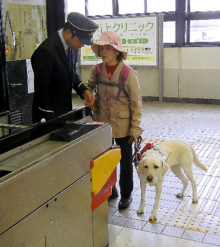 近鉄けいはんな線・吉田駅の改札で駅係員に介助を頼む山本美恵子さん=2016年11月