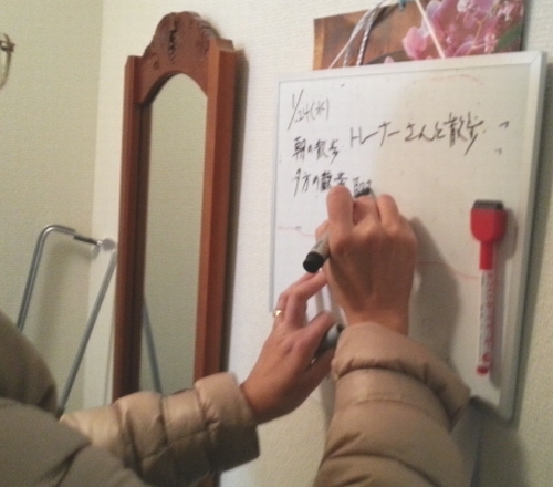 ボードにパクの散歩情報(何時に誰が付き添うか)を書いている