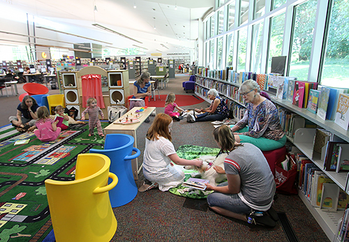 図書館の子どもコーナーの床のあちこちに散らばり、読み聞かせチームがそれぞれの島を作る