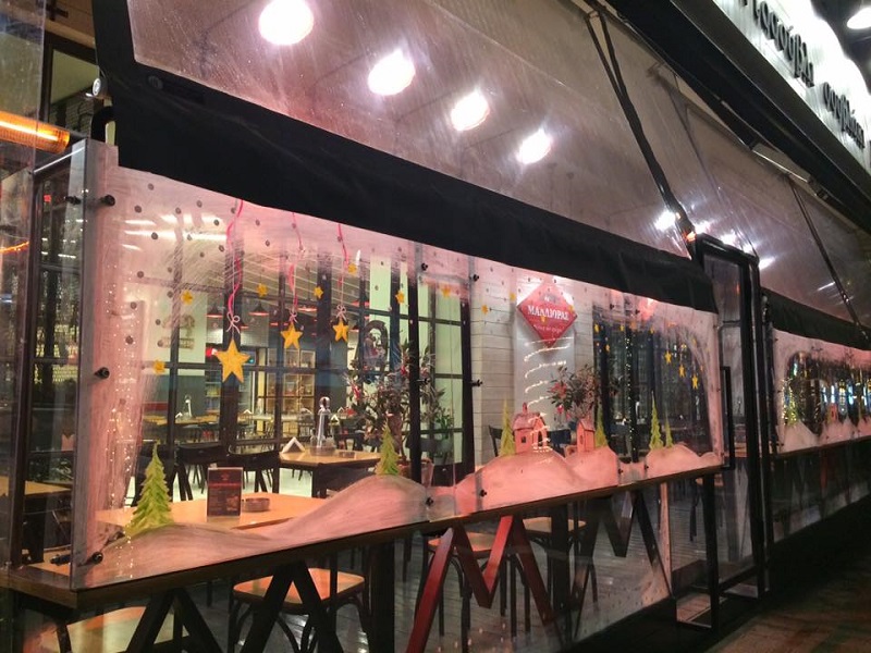 これが「お店の外側に透明な囲いを作ってできる屋外席」。クリスマスシーズンには街中のガラスドアや囲いがこんな風にペイントされて目に楽しい(ラリサ市)