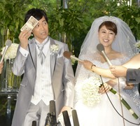 取り出した札束で汗をぬぐう東貴博（左）と安めぐみ＝2012年