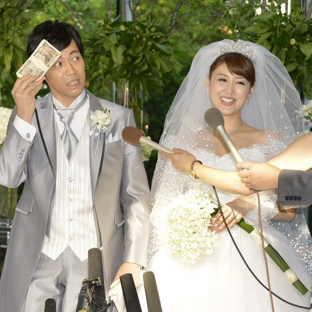 取り出した札束で汗をぬぐう東貴博（左）と安めぐみ＝2012年