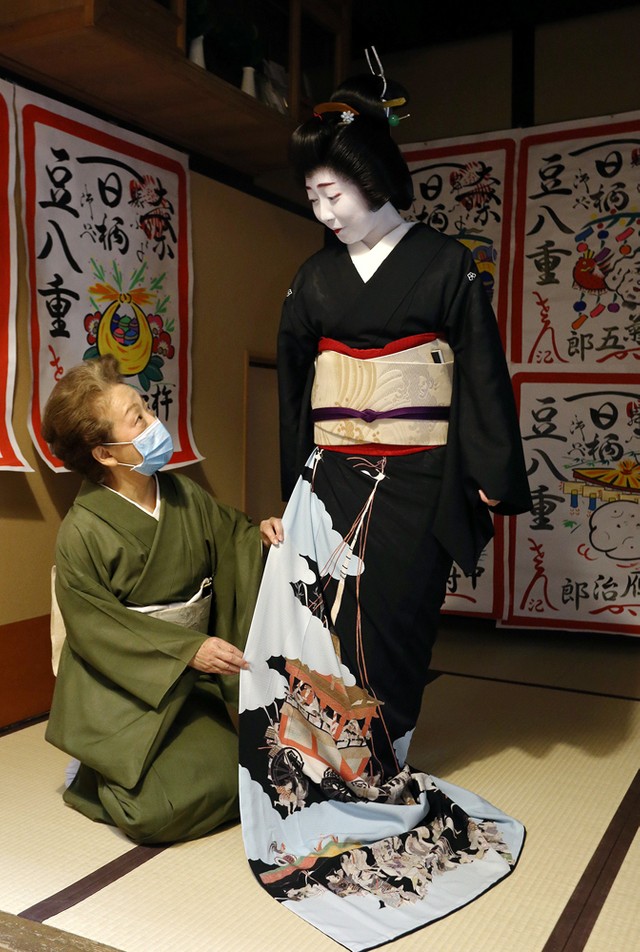 祇園祭を描いた黒紋付きに身を包み、店出しの日を迎えた豆八重さん（右）と女将の市園さん＝京都市中京区・大市