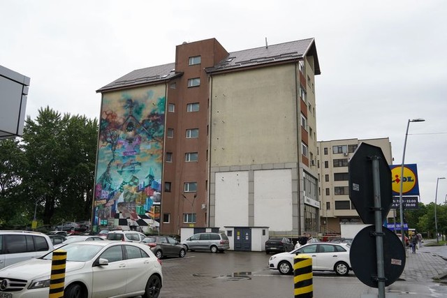 集合住宅の側面に描かれた「空気をきれいにする壁画」=2024年4月25日、ルーマニア北部バカウ、荒ちひろ撮影