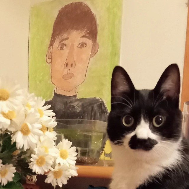 息子さんの自画像をバックに