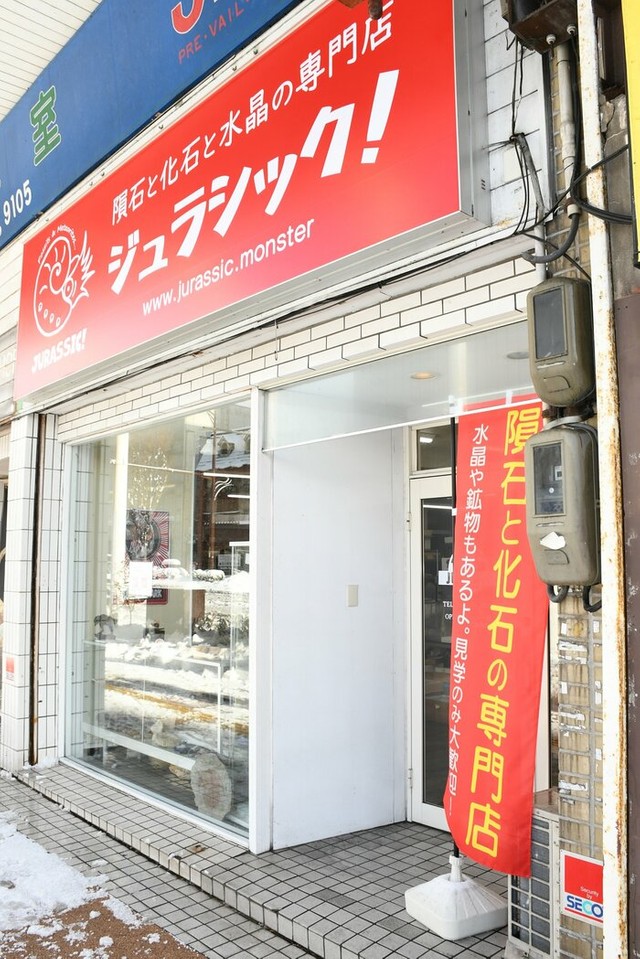 赤い看板とのぼりに「化石」「隕石」といった文字。商店街では目立つ外観だ