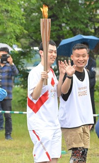 伴走者と共に聖火をつなぐ濱田祐太郎（左）＝2021年5月撮影