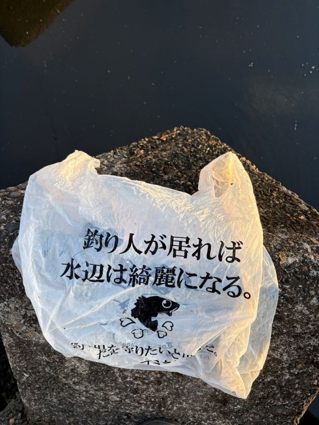 水辺で発見した「釣り人が居れば水辺は綺麗になる」と書かれた袋。 ※taikiさん提供