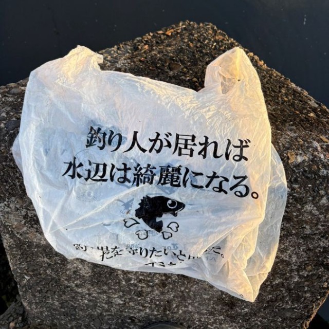水辺で発見した「釣り人が居れば水辺は綺麗になる」と書かれた袋。 ※taikiさん提供