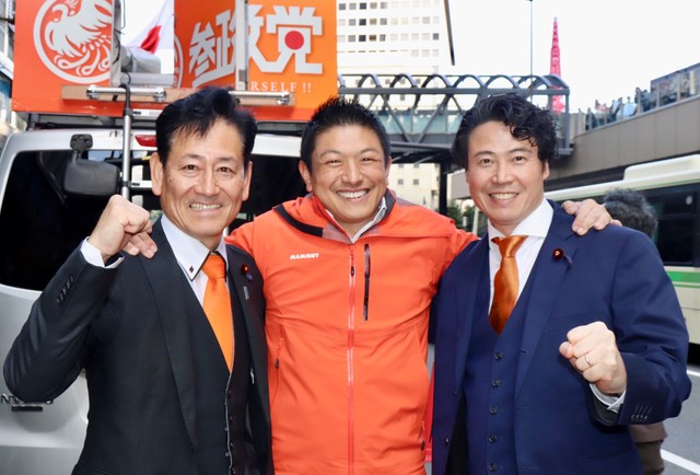 衆院選で初当選した参政党の石川勝（左）、谷浩一郎（右）両衆院議員と肩を組む神谷宗幣代表（中央）＝大阪市内