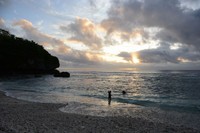 夕暮れ時に、ニウエのビーチで遊ぶ親子