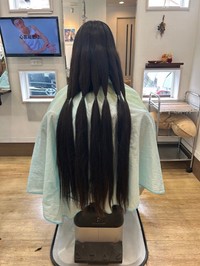 寄付用の髪を切る女子中学生（八幡市美濃山・カルム）＝横村さん提供
