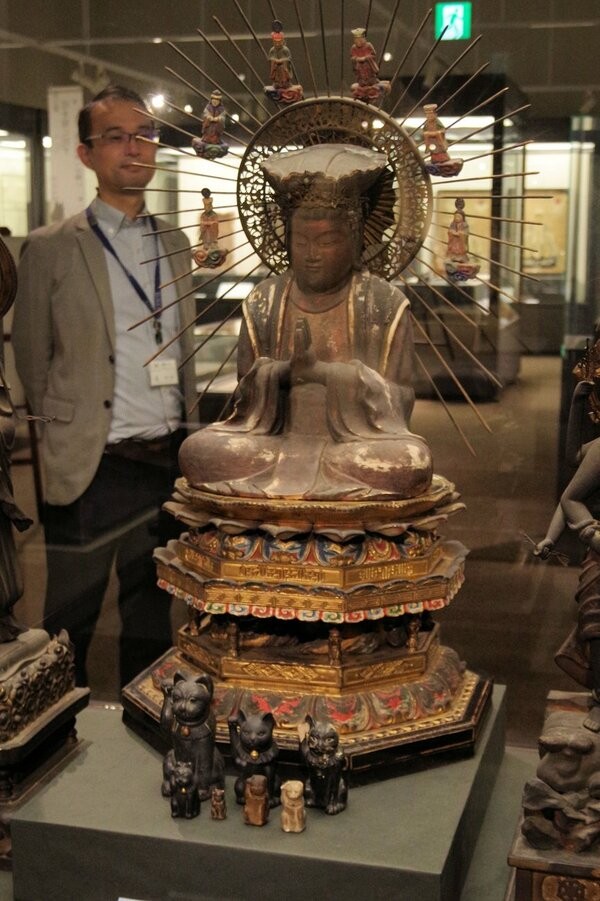 特別展で公開された主夜神像。使いとされる招き猫が前に並ぶ（京都市右京区・佛教大宗教文化ミュージアム）