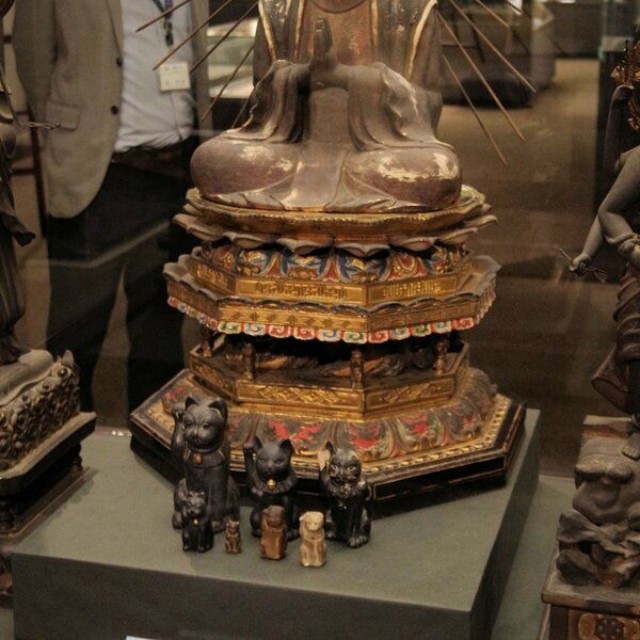 特別展で公開された主夜神像。使いとされる招き猫が前に並ぶ（京都市右京区・佛教大宗教文化ミュージアム）