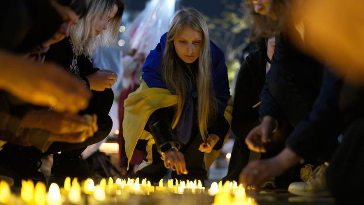 ロシアによるウクライナ侵攻が始まって4年となった4月24日、ウクライナ支援集会で犠牲者を悼み、あかりをともす参加者たち
