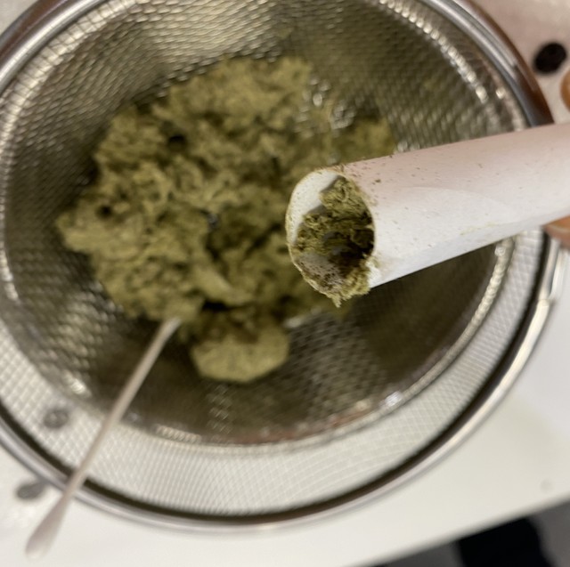 篩の下に落ちた柔毛を、紙で作った筒に詰めます。