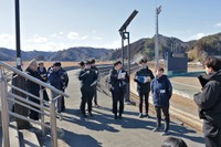 かつて「万里の長城」と呼ばれた防潮堤の上で津波被害について語る元田さん（右から２人目）＝岩手県宮古市田老
