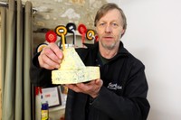 スティルトンチーズを手に持つロバート・ゴスリングさん=2021年3月3日、英中部ダービーシャー、和気真也撮影
