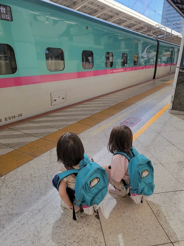 新幹線のリュックを背負い、はやぶさを見つめる子どもたち。家族で東京駅へ見学に訪れたという／MOEさん（@hoppe.mochimochi）提供