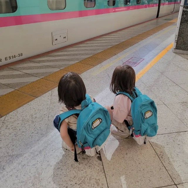 新幹線のリュックを背負い、はやぶさを見つめる子どもたち。家族で東京駅へ見学に訪れたという／MOEさん（@hoppe.mochimochi）提供