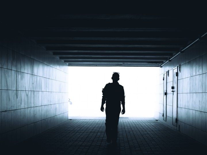 暗がりを抜けて、光のほうへ。　Silhouette of a woman walking in the underpass［original photo：Klochkov – stock.adobe.com］