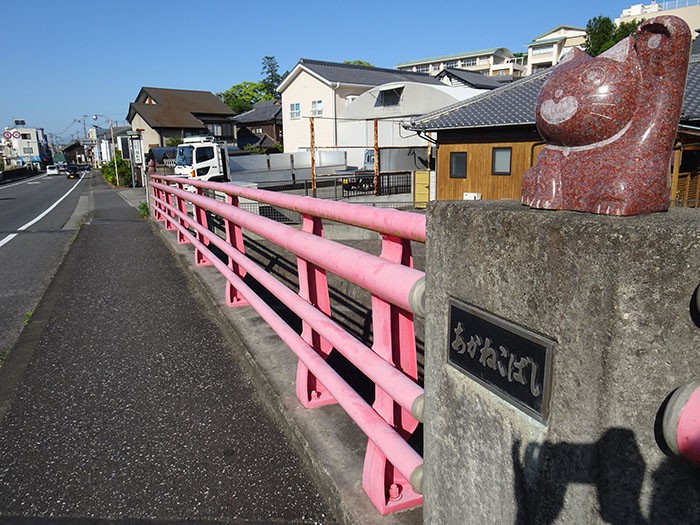 柱の上に赤猫がいる「赤猫橋」は市内を流れる小河内川にかかる橋。かつては別な名前の橋でしたが、2005年にこの名前に
