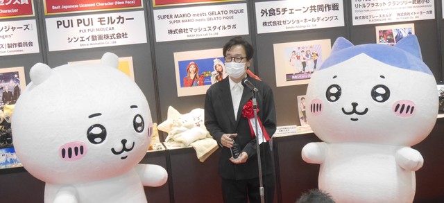 ちいかわ（左）、ハチワレ（右）に挟まれ、表彰を喜ぶスパイラルキュート社の川上洋一代表＝都内