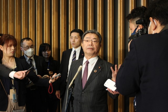 報道陣の取材に応える谷公一国家公安委員長（中央）＝２６日、東京都千代田区