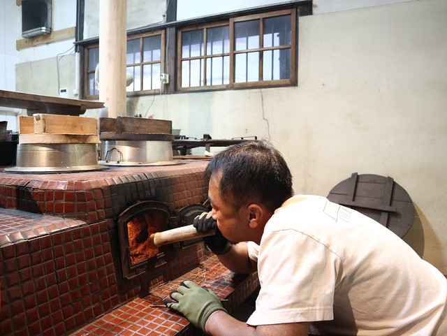120年前の「おくどさん」で薪を燃やして飯を炊く植月さん