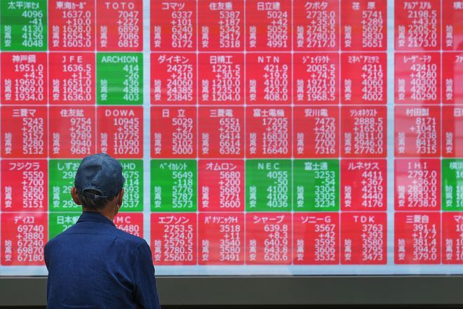 Asian shares are mostly higher, tracking Wall Street’s fresh records, and oil prices fall