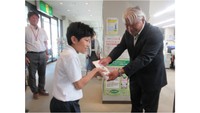 集まった募金を手渡す児童（提供：美作市立江見小学校）