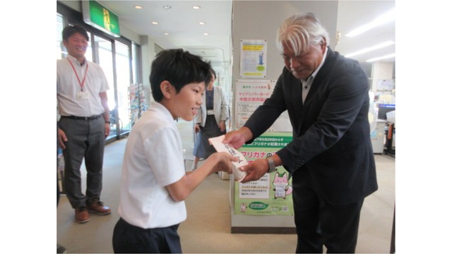 集まった募金を手渡す児童（提供：美作市立江見小学校）