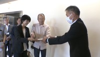 香川県議会事務局に陳情書を手渡す市民団体の代表者ら