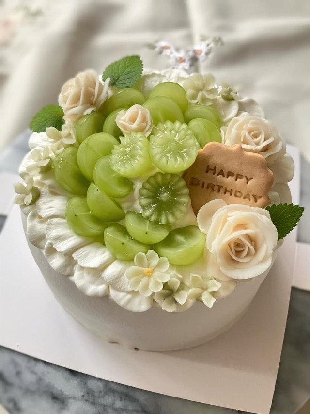 過去に手がけた誕生日ケーキ。シャインマスカットとバラの絞りをあしらった一台／癒やシフォンさん（@iyachiffon）提供