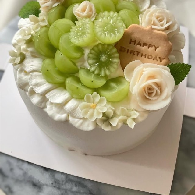 過去に手がけた誕生日ケーキ。シャインマスカットとバラの絞りをあしらった一台／癒やシフォンさん（@iyachiffon）提供