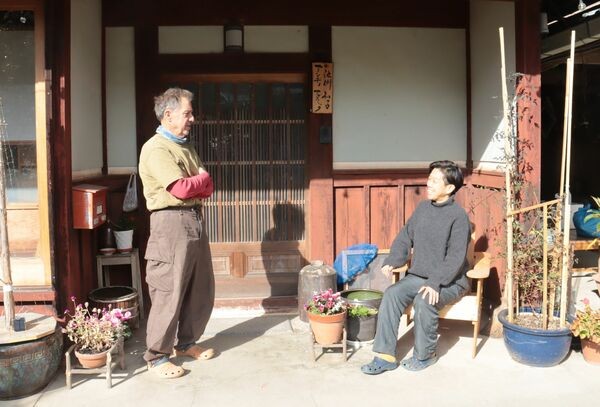 玄関先で談笑するアンディさんと和子さん（南丹市園部町）
