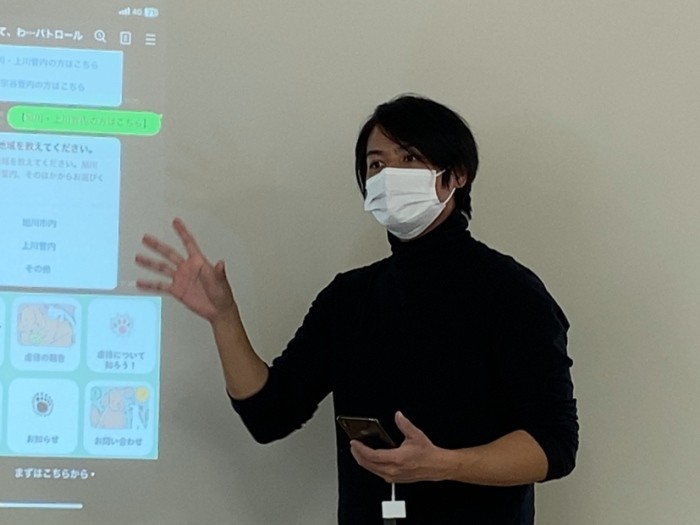 「特定非営利活動法人　手と手の森」理事の増永隆志さん。公式LINEを担当。LINE上でどのように飼い主さんの相談を受け付けるかを「あにまある」の職員さんへ説明