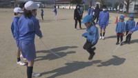 一緒に縄跳びをして交流する児童と園児